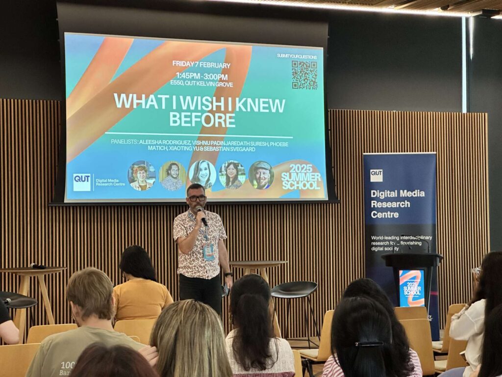 Speaker on a podium before a presentation entitled “What I Wish I Knew Before”